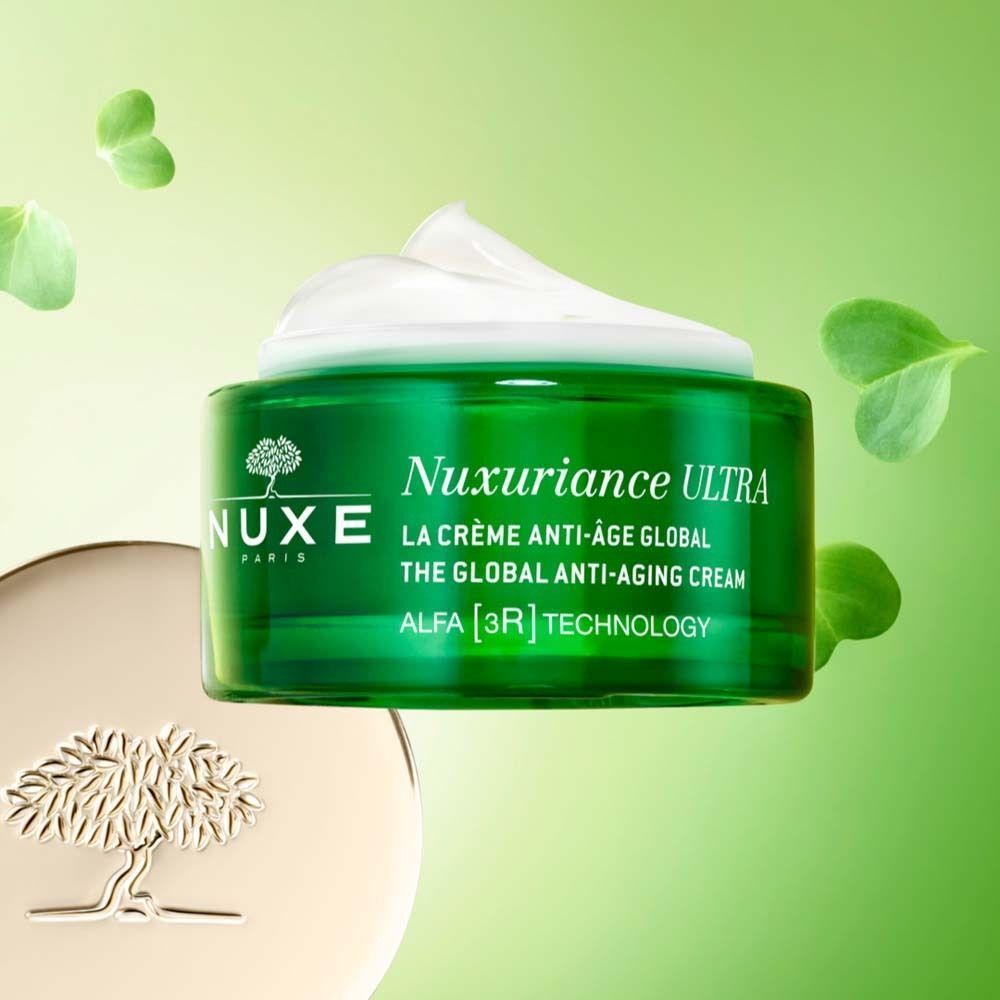 Grünes Creme-Glas mit weißer Creme. Goldfarbener Deckel. Aufschrift: Nuxuriance Ultra. La Crème Anti-Âge Global. Grüner Hintergrund.