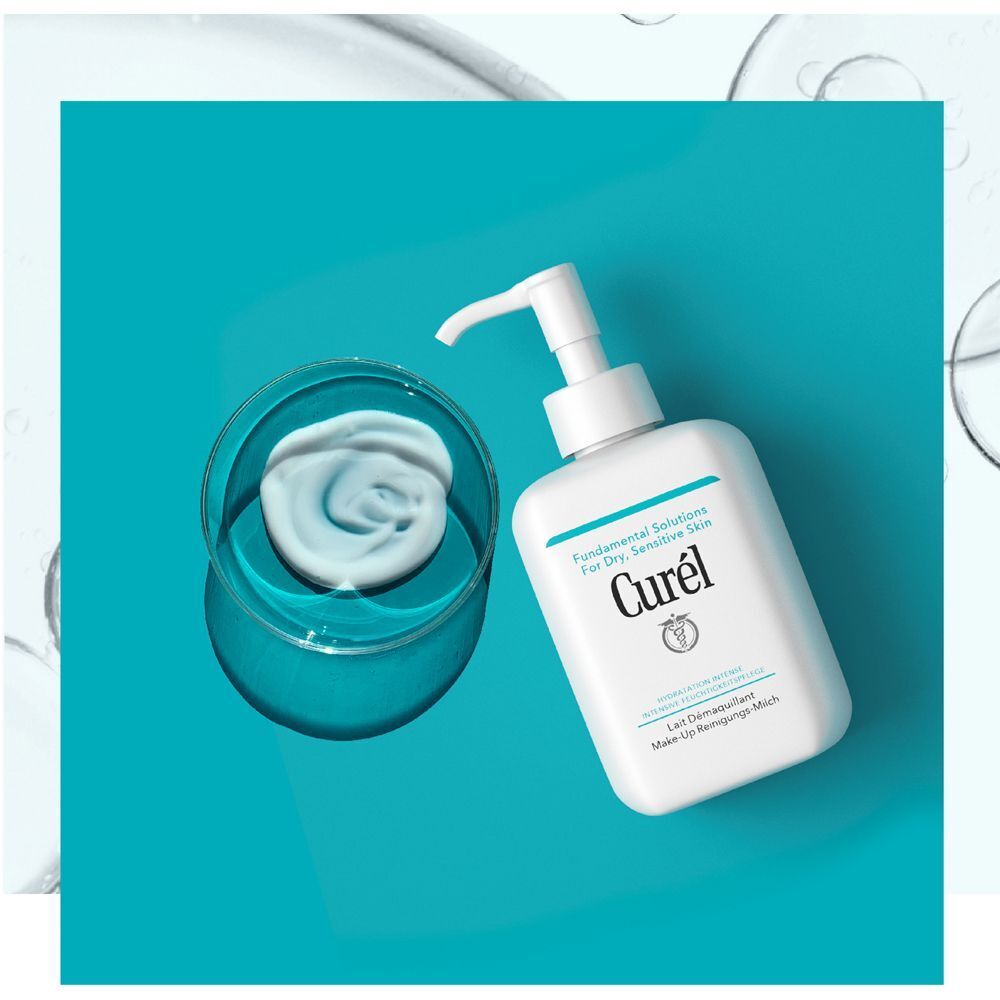 CUREL Make-Up Reinigungs-Milch Flasche mit Pumpaufsatz neben einer Schale mit Produkt. Türkisfarbener Hintergrund.