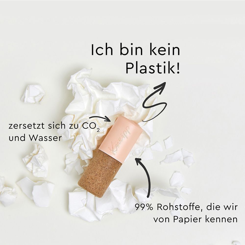Lippenpflegestift neben zerknittertem Papier. Text: Ich bin kein Plastik! Zersetzt sich zu CO2 und Wasser.