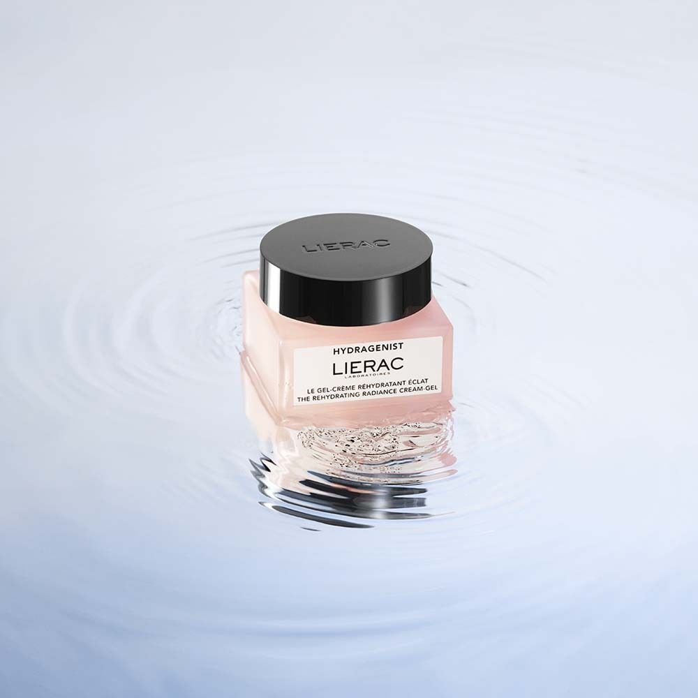 Rosa Tiegel mit schwarzem Deckel im Wasser. Aufschrift: HYDRAGENIST, LIERAC, Le gel-crème réhydratant éclat, The rehydrating radiance cream-gel.
