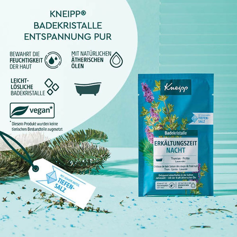 KNEIPP Badekristalle Erkältungszeit Nacht Beutel neben einem Anhänger mit Tiefensalz. Hintergrund: Grün-blau. Vegan-Logo.