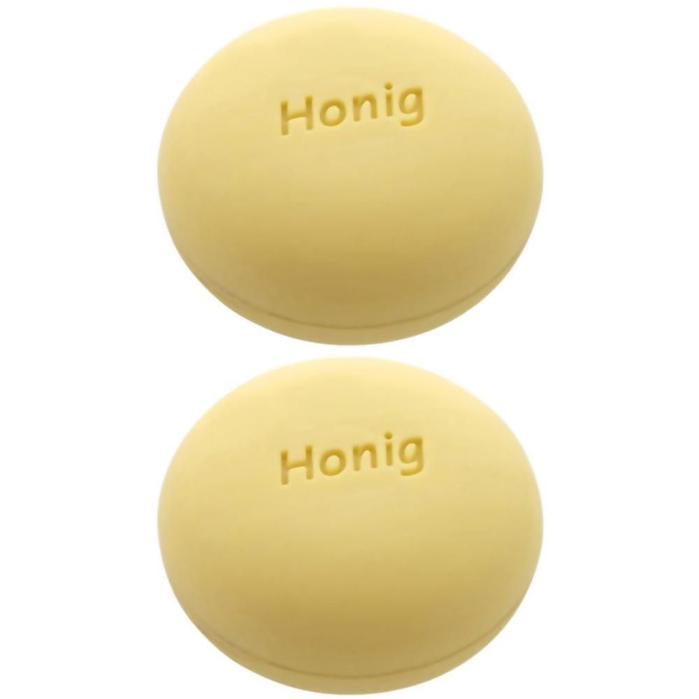 Zwei runde, gelbliche Seifenstücke mit der Prägung "Honig".