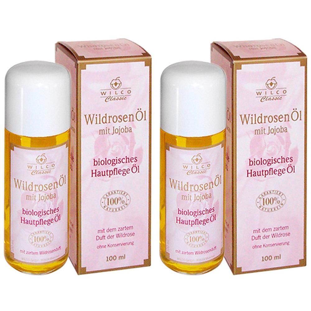 Drei Flaschen und zwei Kartons mit Produktaufdruck. Aufschrift: Wildrosen Öl mit Jojoba, biologisches Hautpflege Öl. 100% naturrein.