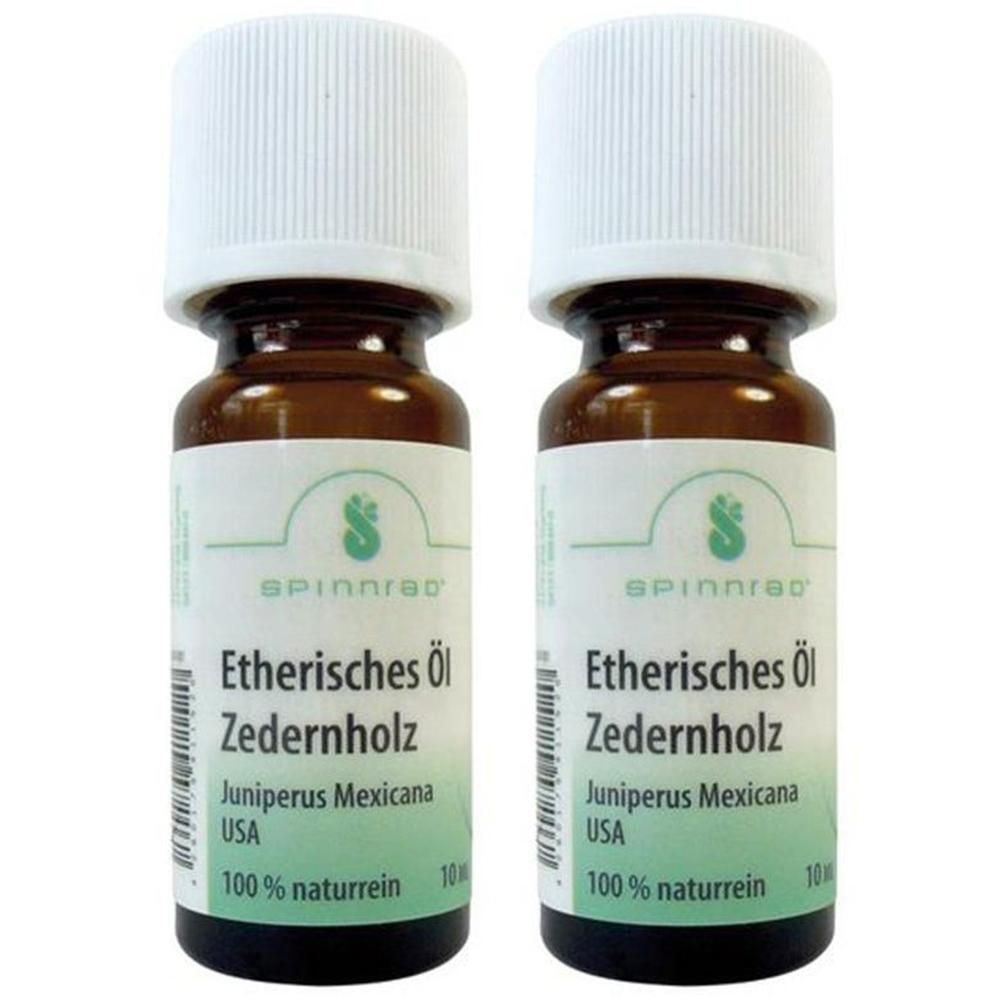 Zwei braune Glasflaschen mit weißem Deckel. Etikett mit Text: Etherisches Öl Zedernholz, 100% naturrein. Marke Spinnrad.