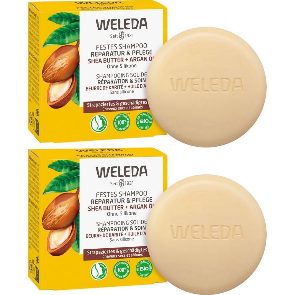Zwei runde, feste Shampoos und zwei gelbe Kartons. Auf den Kartons steht "WELEDA", "FESTES SHAMPOO Reparatur & Pflege".