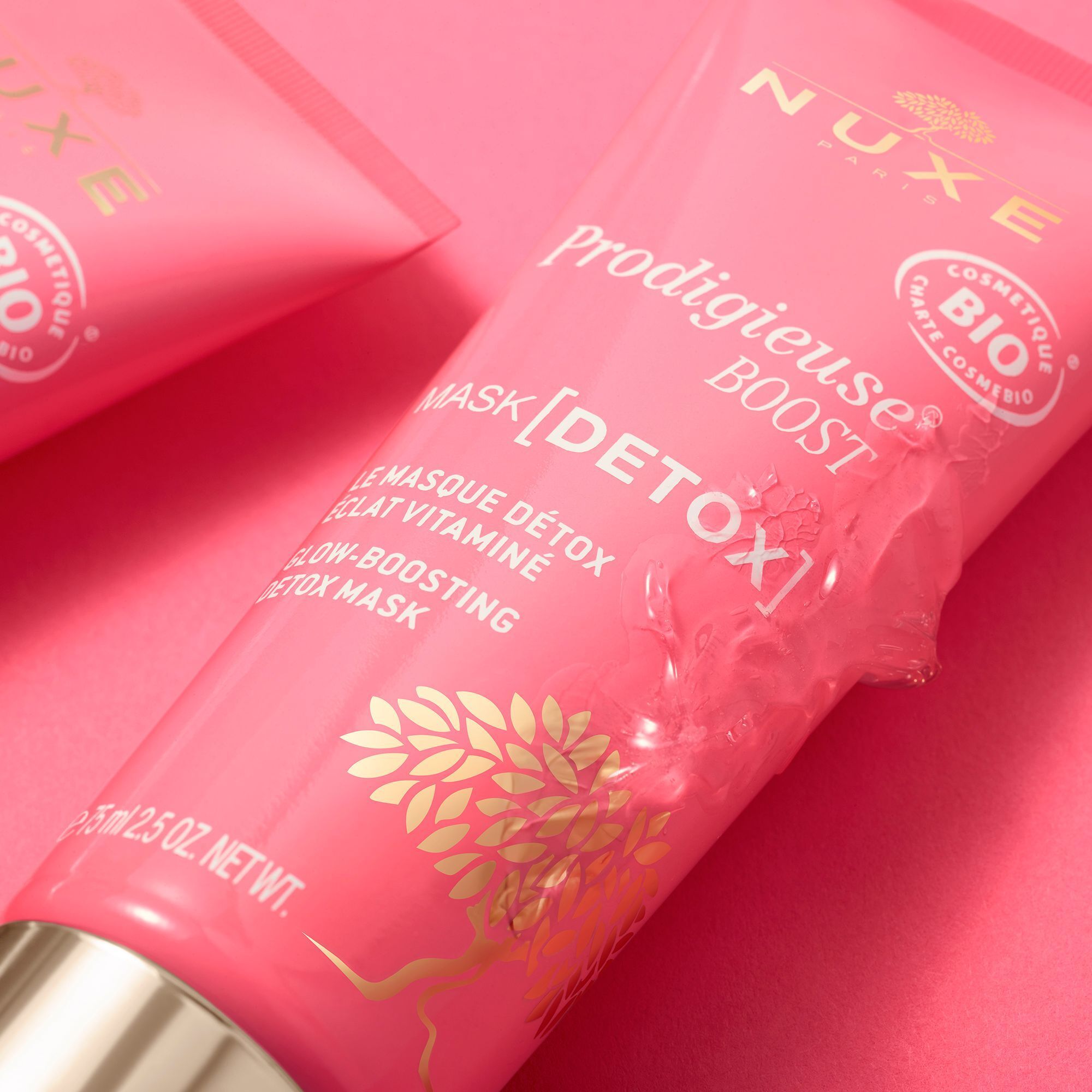 Rosa Tube mit goldfarbenem Verschluss und Produkt. Text: "NUXE Paris", "Prodigieuse Boost", "Mask [Detox]" und "Bio"-Siegel.
