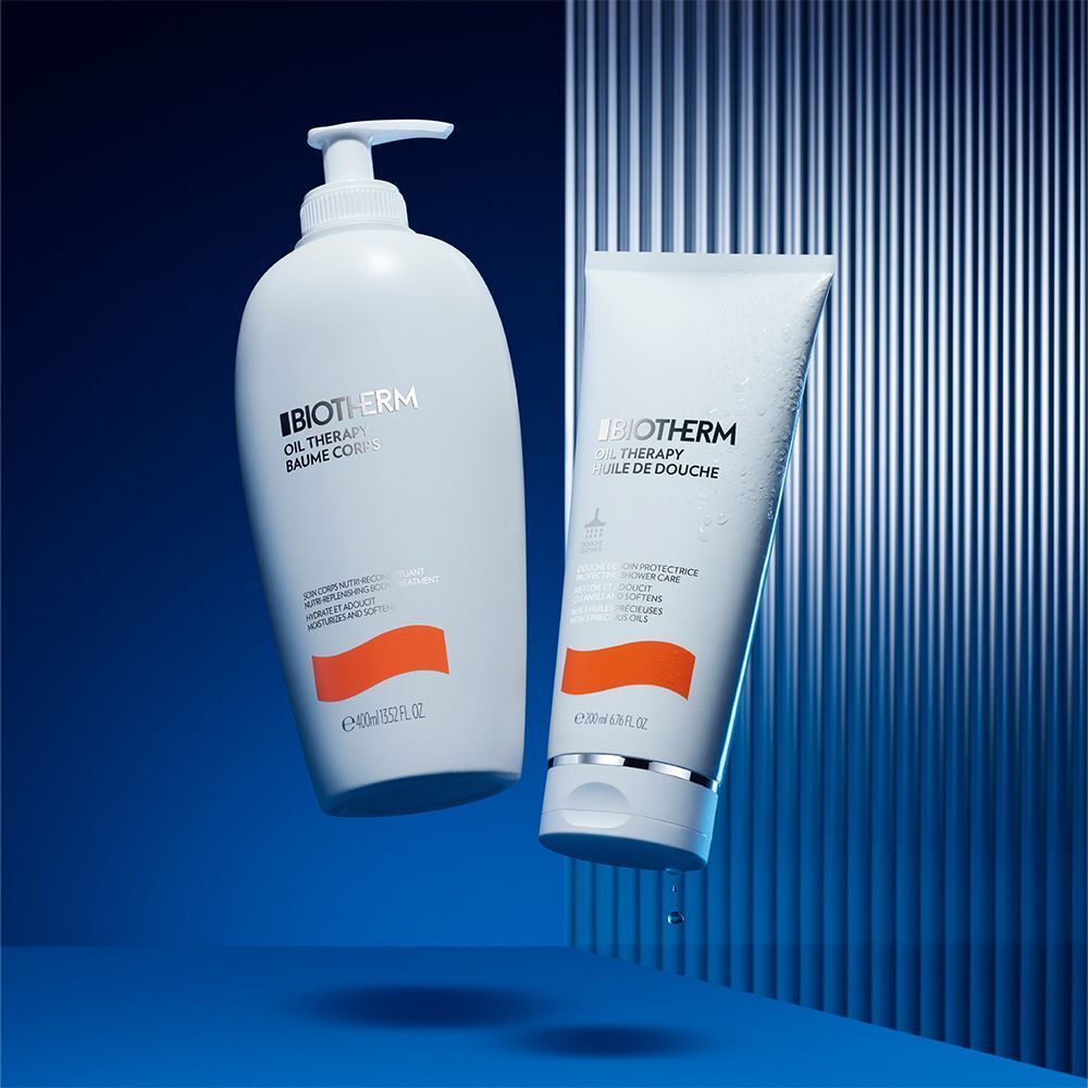 Zwei Produkte: BIOTHERM Oil Therapy Baume Corps und Oil Therapy Huile de Douche. Weiße Flaschen mit orangefarbenen Akzenten, schwebend vor blauem Hintergrund.