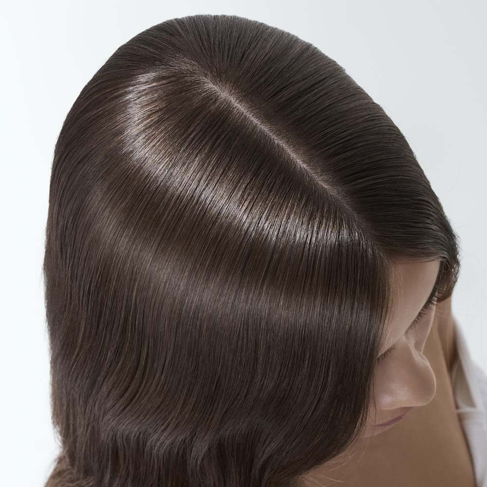 Draufsicht auf das Haar einer Frau. Haare sind sauber, glänzend und liegen glatt. Mittelscheitel sichtbar.