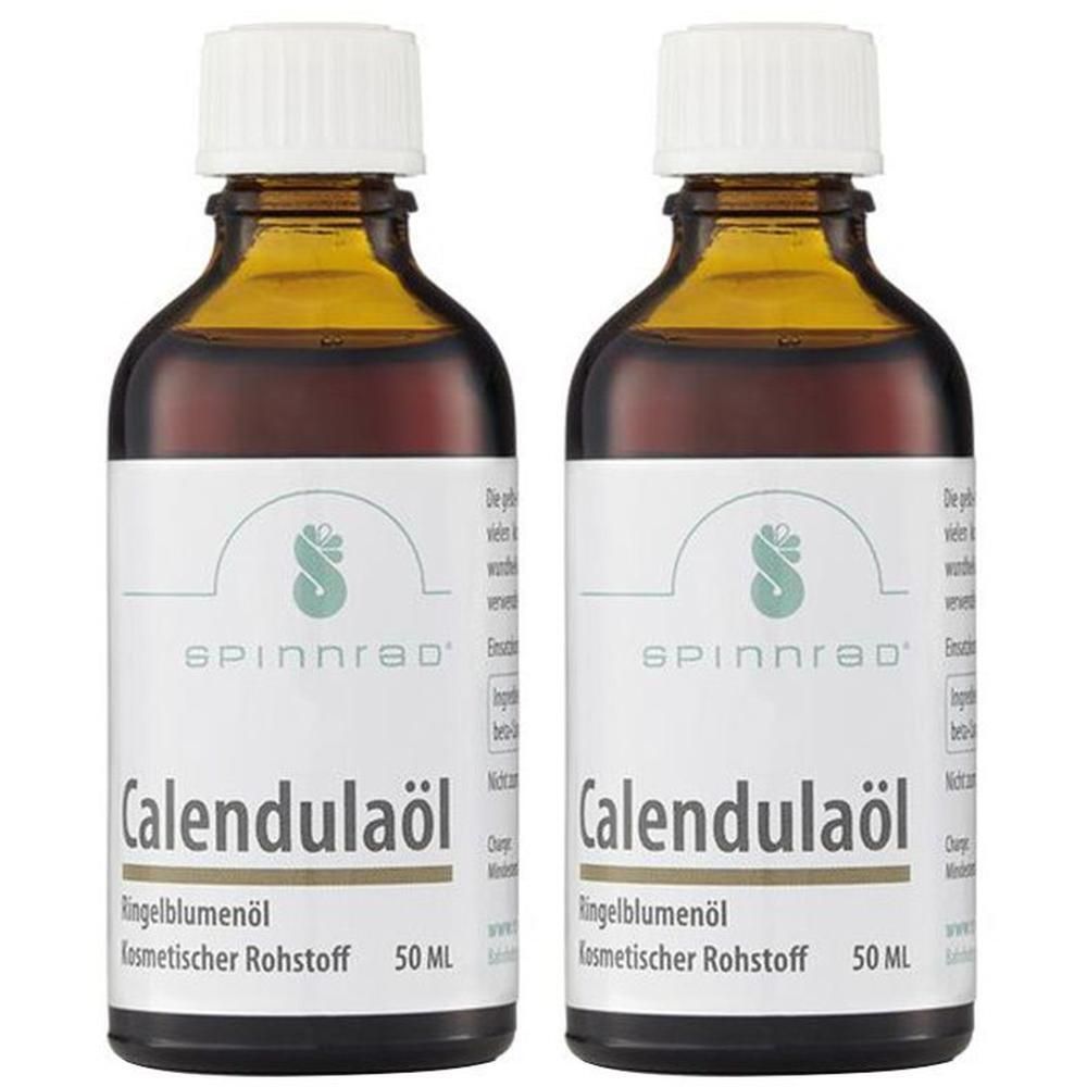 Zwei Flaschen Calendulaöl. Braune Glasflaschen mit weißem Etikett. Aufschrift: Spinnrad Calendulaöl, Ringelblumenöl, 50 ml.