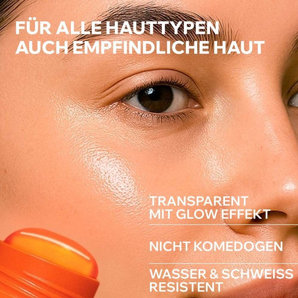 Nahaufnahme eines Gesichts. Sonnenschutzstift wird aufgetragen. Text: Transparent mit Glow-Effekt, nicht komedogen, wasserfest.
