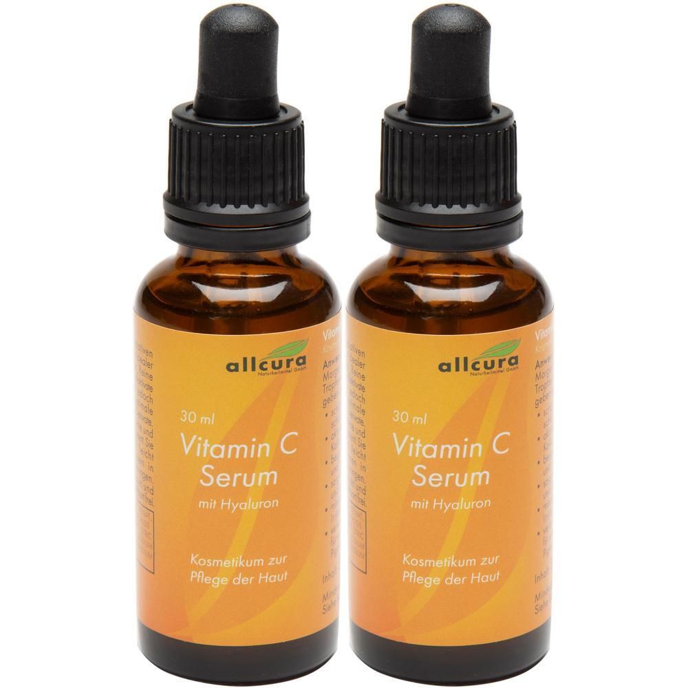 Zwei Flaschen Vitamin C Serum. Braune Glasflaschen mit schwarzem Deckel und Pipette. Orangefarbenes Etikett mit Produktinformationen.