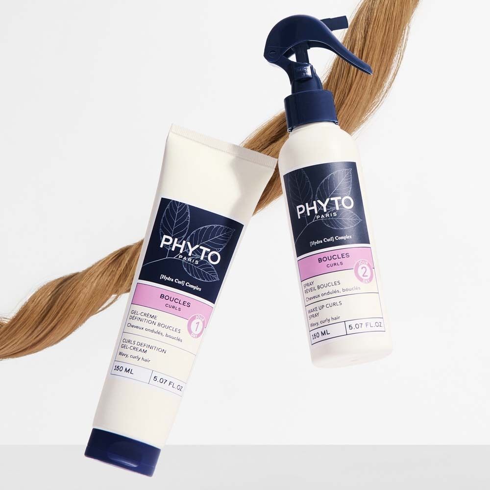 Eine Tube und eine Sprühflasche PHYTO PARIS Curls. Weiße Verpackung mit blauen und rosa Etiketten. Text: Curls, Gel-Creme, 150 ml, 5.07 FL.OZ.