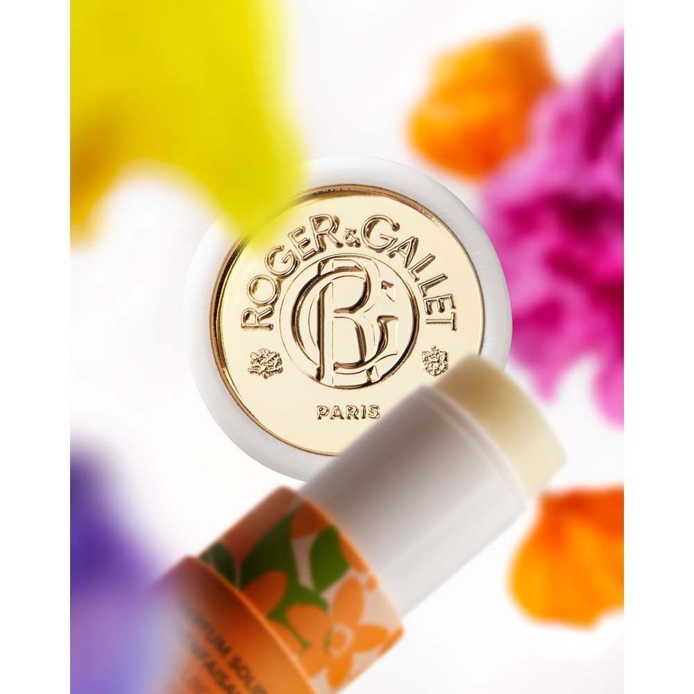 Geöffneter zylindrischer Behälter. Weiß mit goldenem Deckel. Marke Roger & Gallet. Umgeben von bunten Blüten.