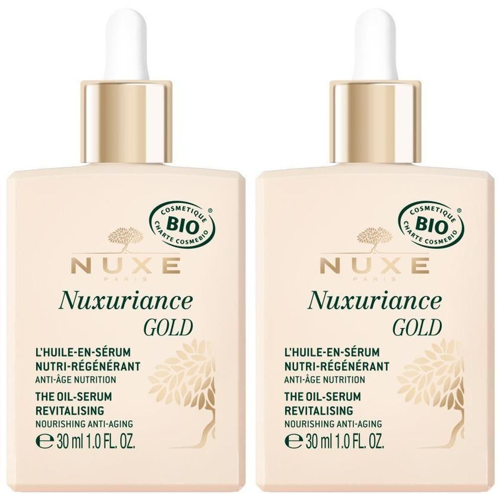 Zwei quadratische Flakons NUXE Nuxuriance Gold Öl-Serum. Goldfarbene Deckel mit Pipetten. Aufschrift: Nuxuriance GOLD, L'HUILE-EN-SÉRUM, e 30 ml.