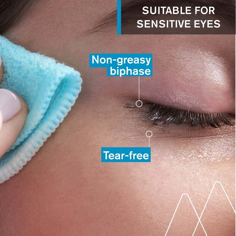 Nahaufnahme eines Auges, das mit einem blauen Wattepad gereinigt wird. Text: Non-greasy biphase, Tear-free.