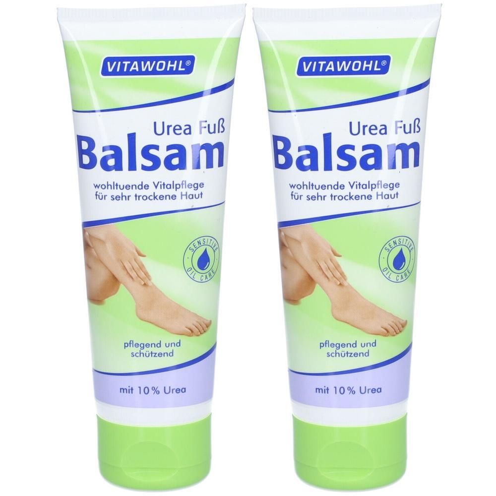 Zwei Tuben VITAWOHL Urea Fuß Balsam. Weiß-grüne Verpackung mit Produktnamen, Illustration eines Fußes und Text. Enthält 10% Urea.