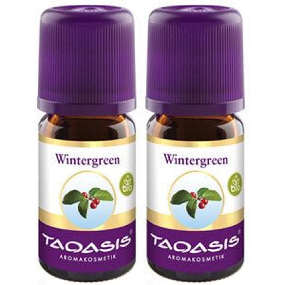 Zwei Flaschen TAOASIS® Wintergreen BIO. Braune Glasflaschen mit lila Deckel. Etikett mit Wintergreen-Schriftzug, Blättern und Beeren.