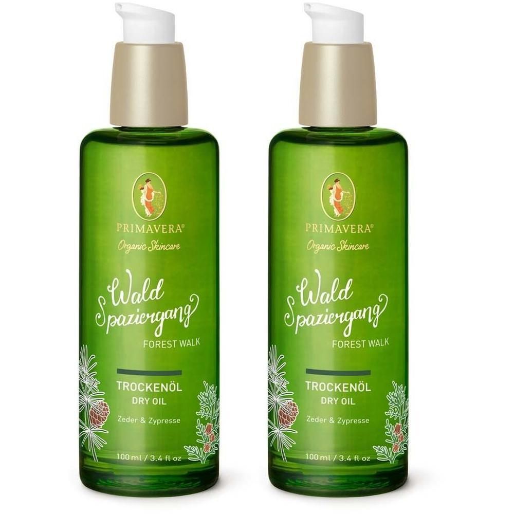 Zwei grüne Flaschen mit Pumpaufsatz. Aufschrift: PRIMAVERA, Wald Spaziergang, Trockenöl. Dekoratives Pflanzenmotiv. 100 ml.