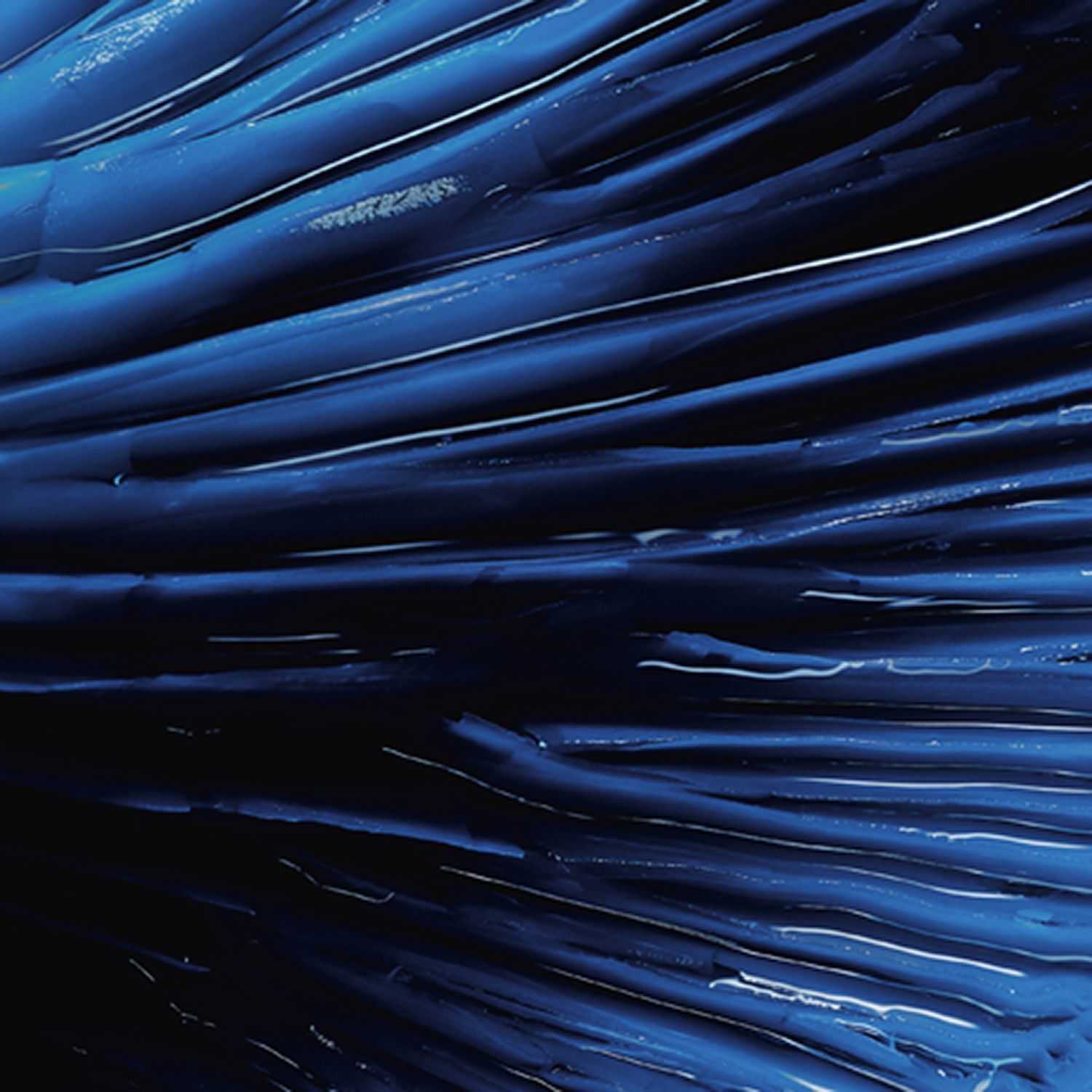 Nahaufnahme einer blauen, cremigen Substanz. Die Textur ist wellig und glänzend. Lichtreflexe.