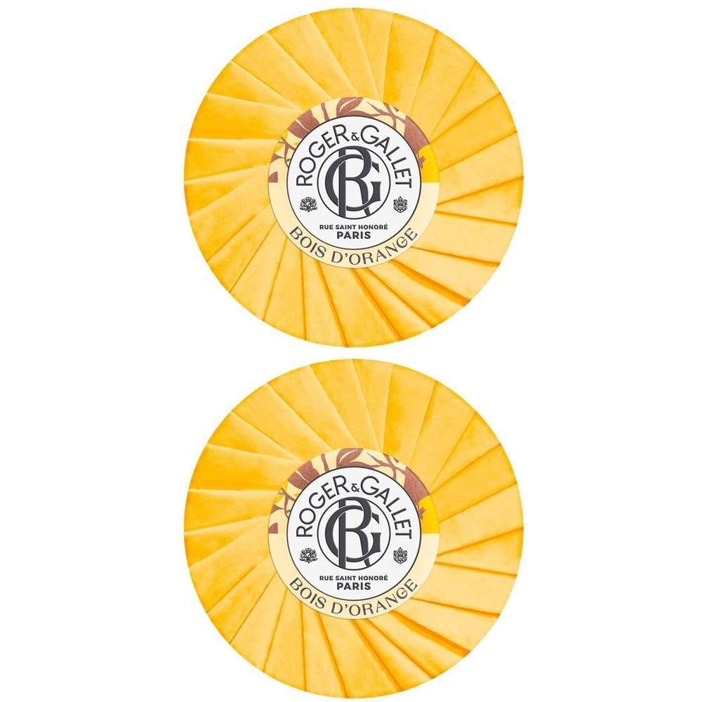 Zwei runde, gelbe Seifen mit Papierverpackung. Auf jeder Seife ist das Logo von Roger & Gallet zu sehen.