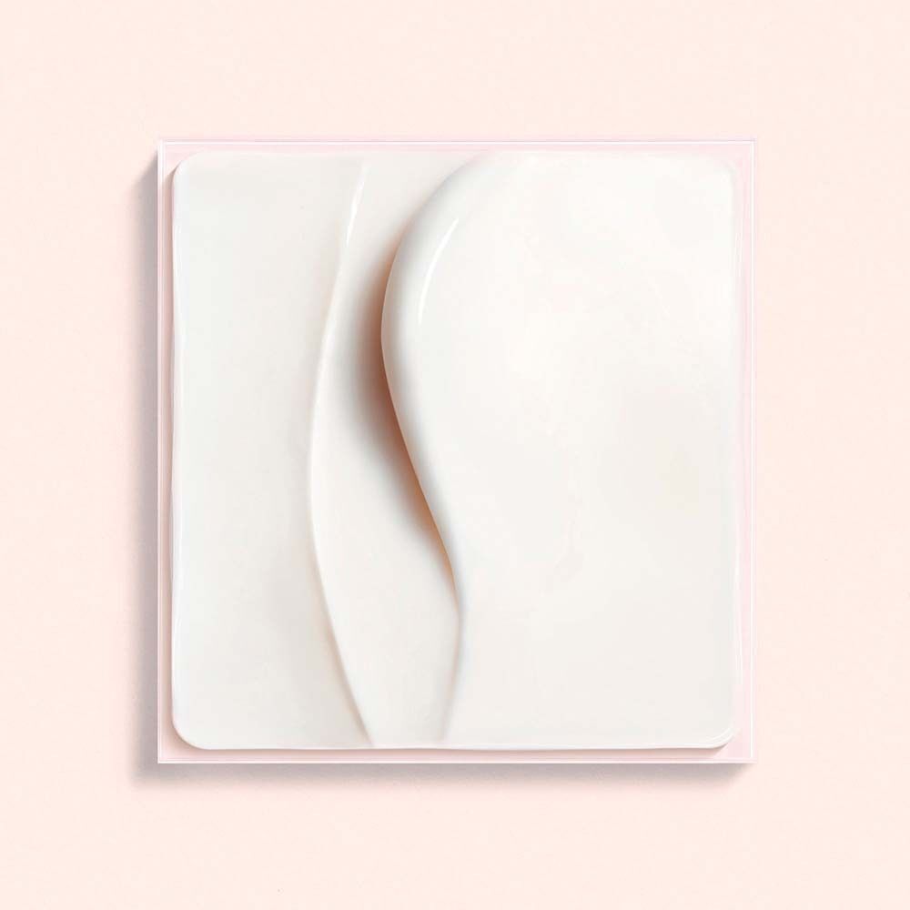 Nahaufnahme einer Creme-Textur. Weiße Creme mit wellenförmigen Linien auf rosa Hintergrund. Quadratische Form.