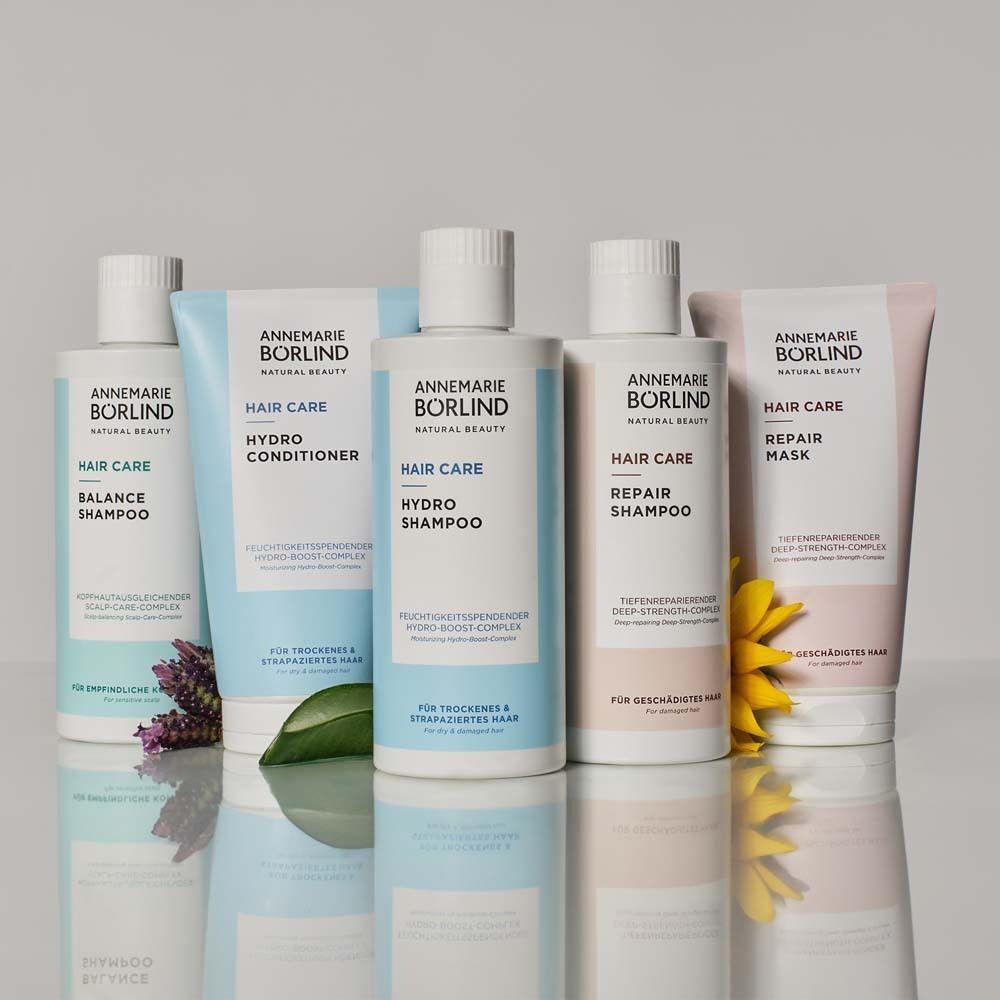 Verschiedene Haarprodukte. Hellblaue und beige Verpackungen. Text: Annemarie Börlind.