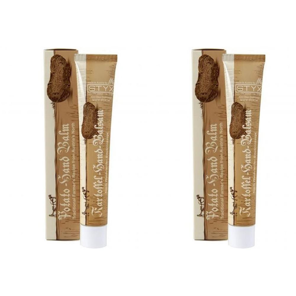 Zwei Tuben und Verpackungen. Aufschrift: Potato-Hand Balm, Kartoffel-Hand-Balsam. Marke STYX. Beige und braune Farben.