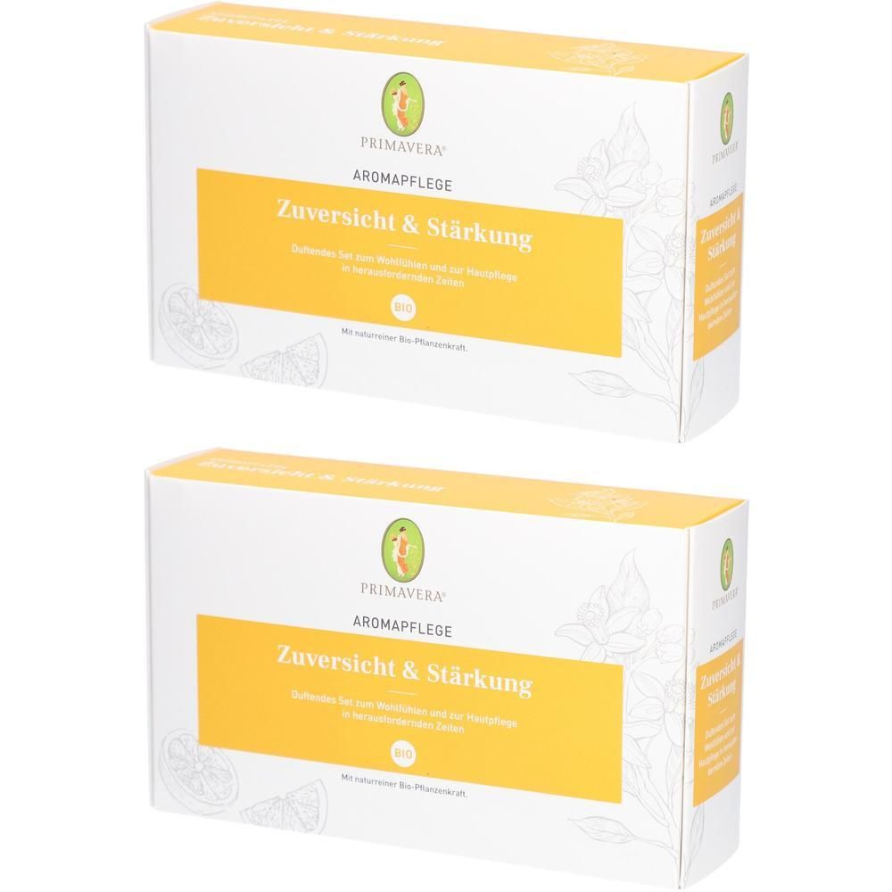 Zwei rechteckige Kartons mit gelbem Streifen und Text. Oben: PRIMAVERA, Aromapflege, Zuversicht & Stärkung. Weiße Verpackung mit floralen Elementen.