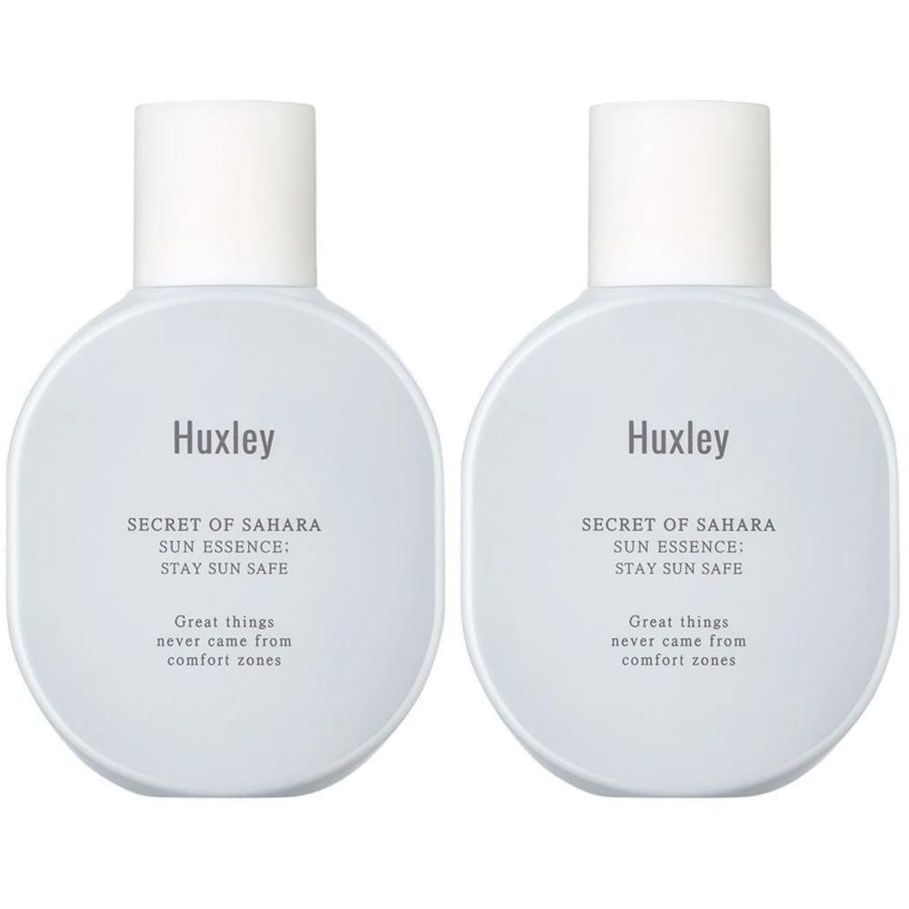 Zwei ovale Flaschen mit weißem Deckel. Auf jeder Flasche steht "Huxley", "SECRET OF SAHARA SUN ESSENCE: STAY SUN SAFE" und ein Zitat.