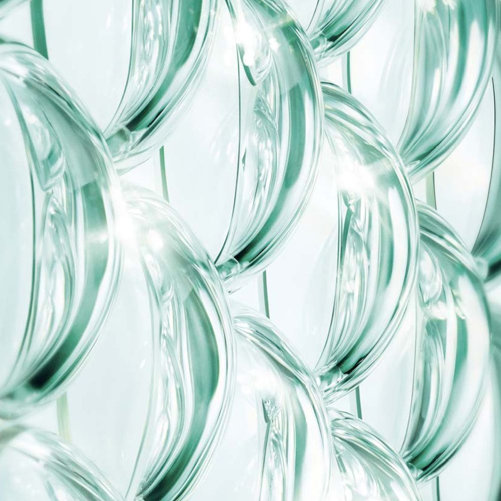 Nahaufnahme von transparenten, blasenartigen Strukturen. Sie sind in einem sich wiederholenden Muster angeordnet und leicht grünlich getönt.