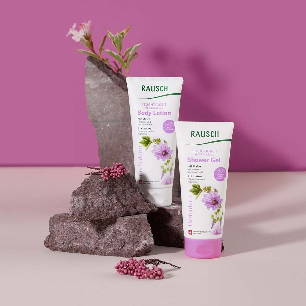 Zwei Tuben Body Lotion und Duschgel. Auf Steinen platziert. Hintergrund in Rosa.