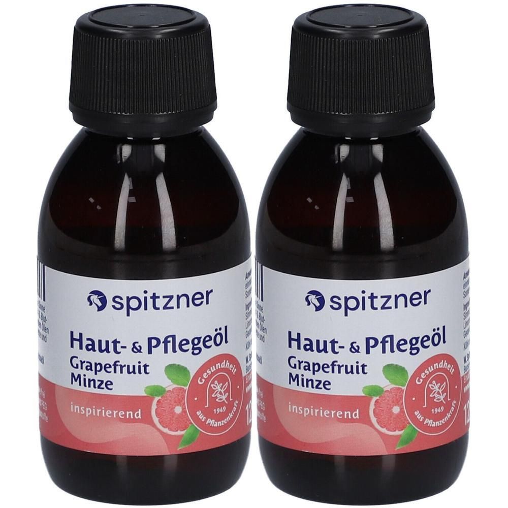 Zwei Flaschen Haut- & Pflegeöl. Schwarze Kappen, weiße Etiketten mit Produktinformationen und Logo. Grapefruit-Minze.