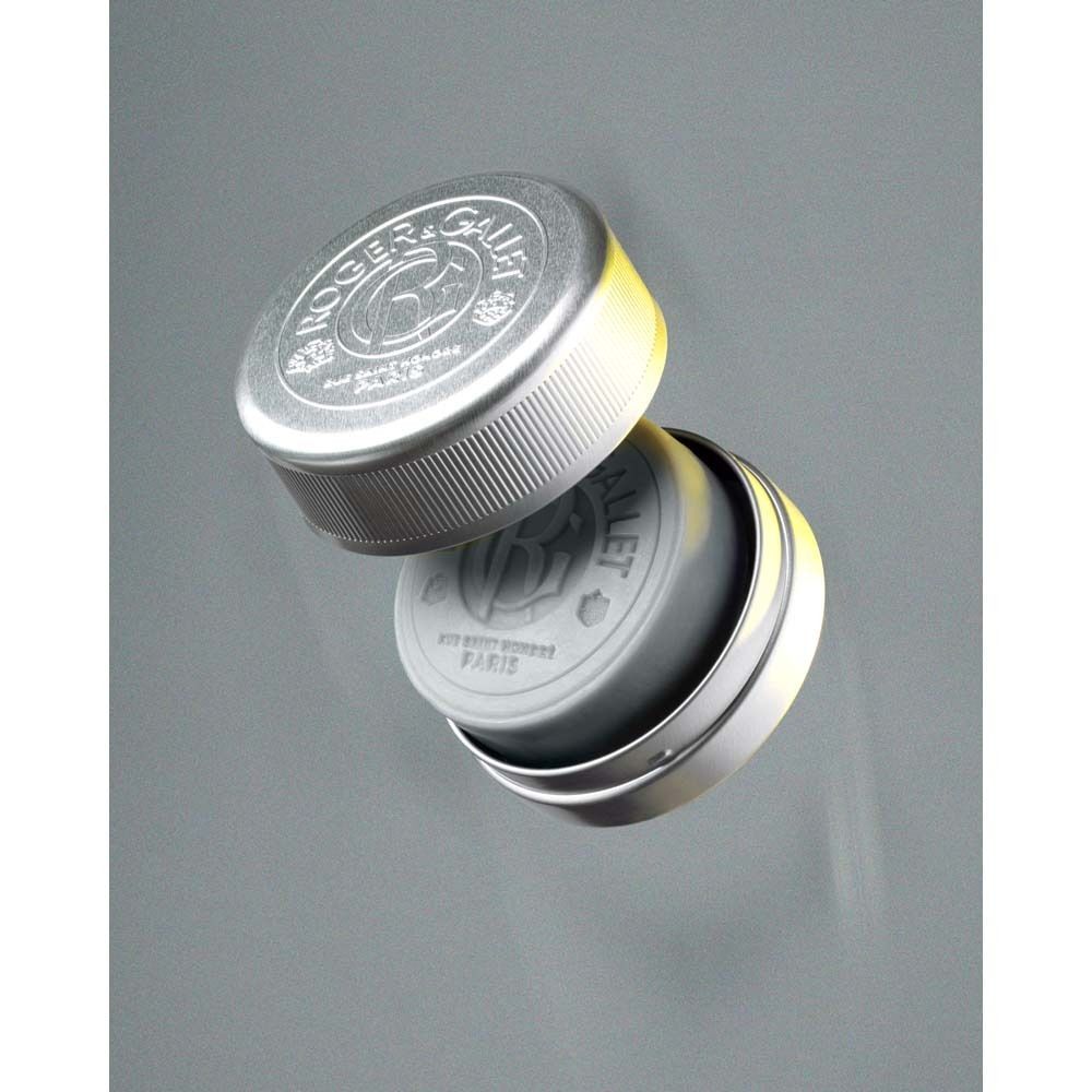 Graue Rasierseife in einer silbernen Dose. Der Deckel ist geöffnet. Auf der Seife ist ein Logo zu sehen. Dose mit Rillen.