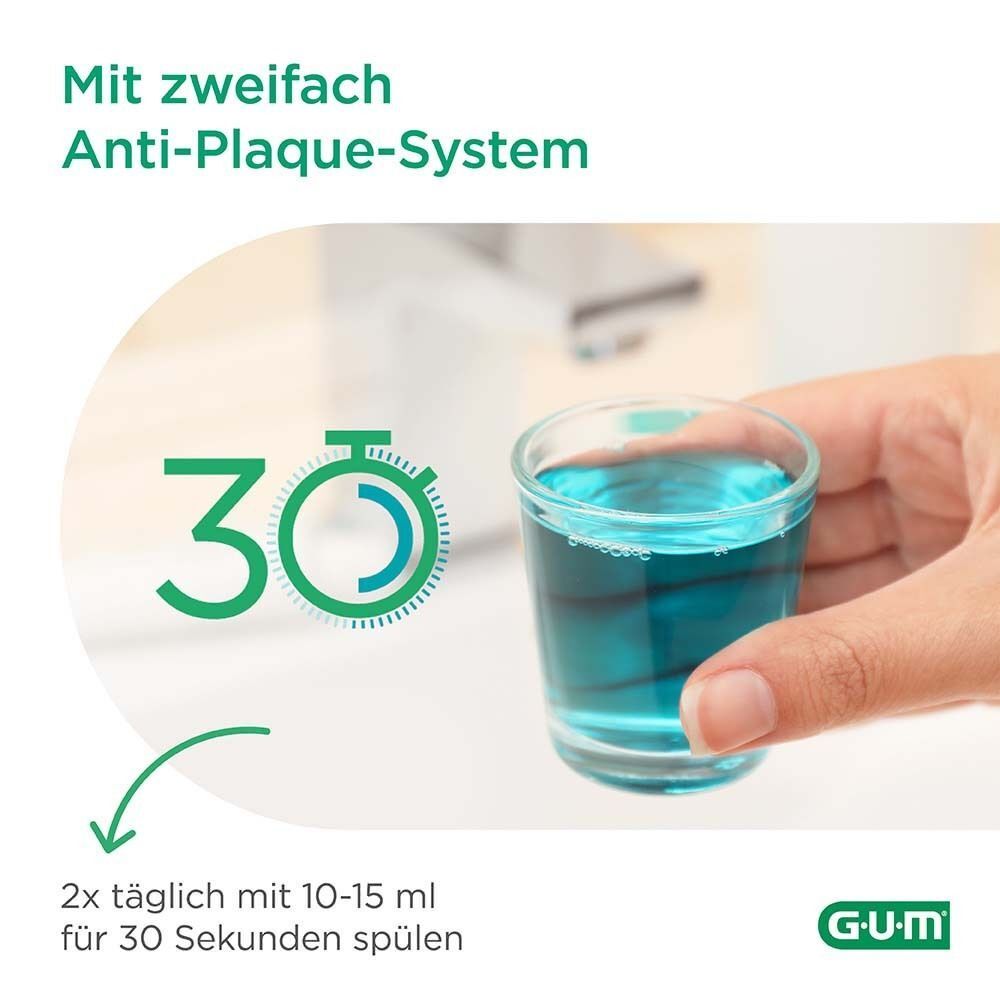 Glas mit blauer Flüssigkeit. Aufschrift: Mit zweifach Anti-Plaque-System. 30 Sekunden spülen. 2x täglich.