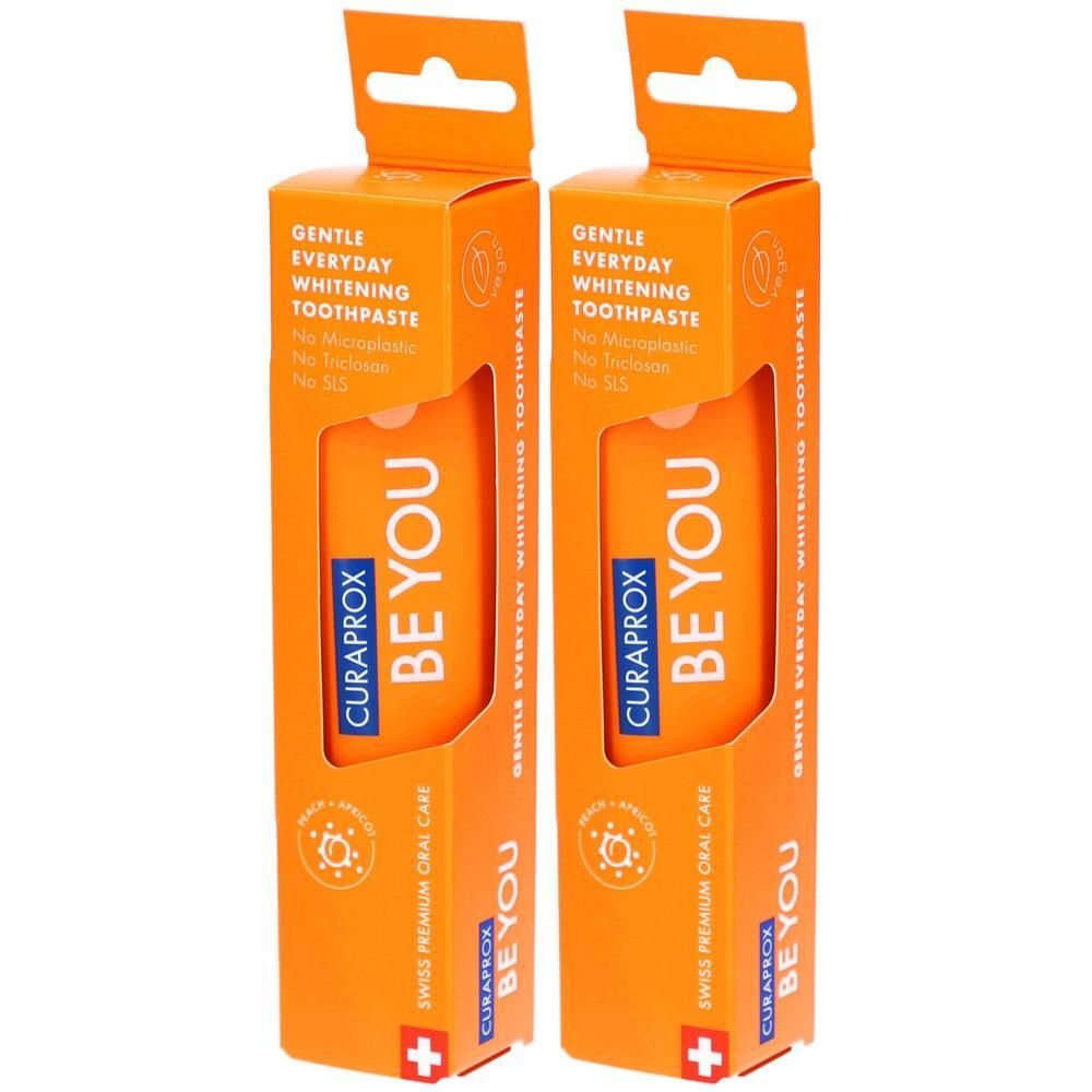 Zwei orangefarbene Verpackungen mit Zahnpasta. Aufschrift: CURAPROX BE YOU, GENTLE EVERYDAY WHITENING TOOTHPASTE. Schweizer Premium Mundpflege.