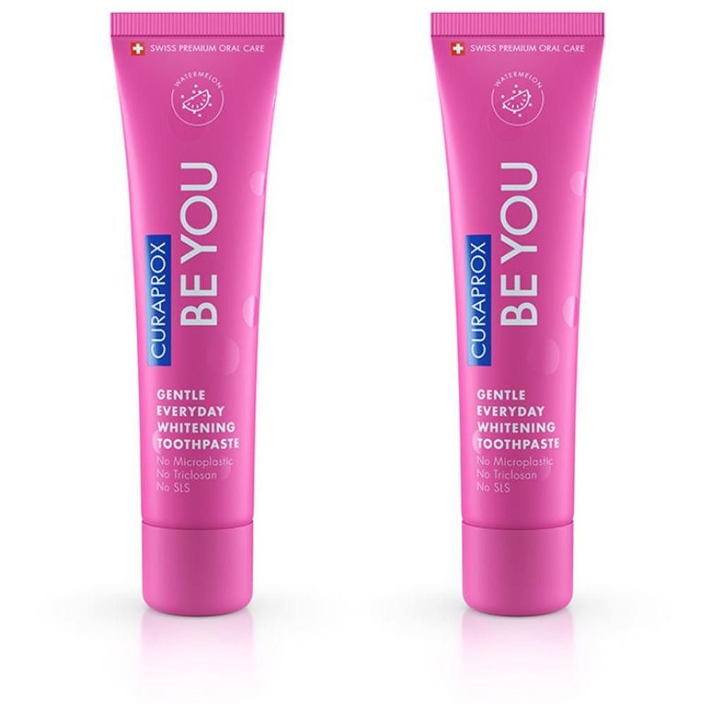 Zwei Tuben Zahnpasta, pinkfarben, mit Schriftzug BE YOU und CURAPROX. Aufschrift: Gentle Everyday Whitening Toothpaste.
