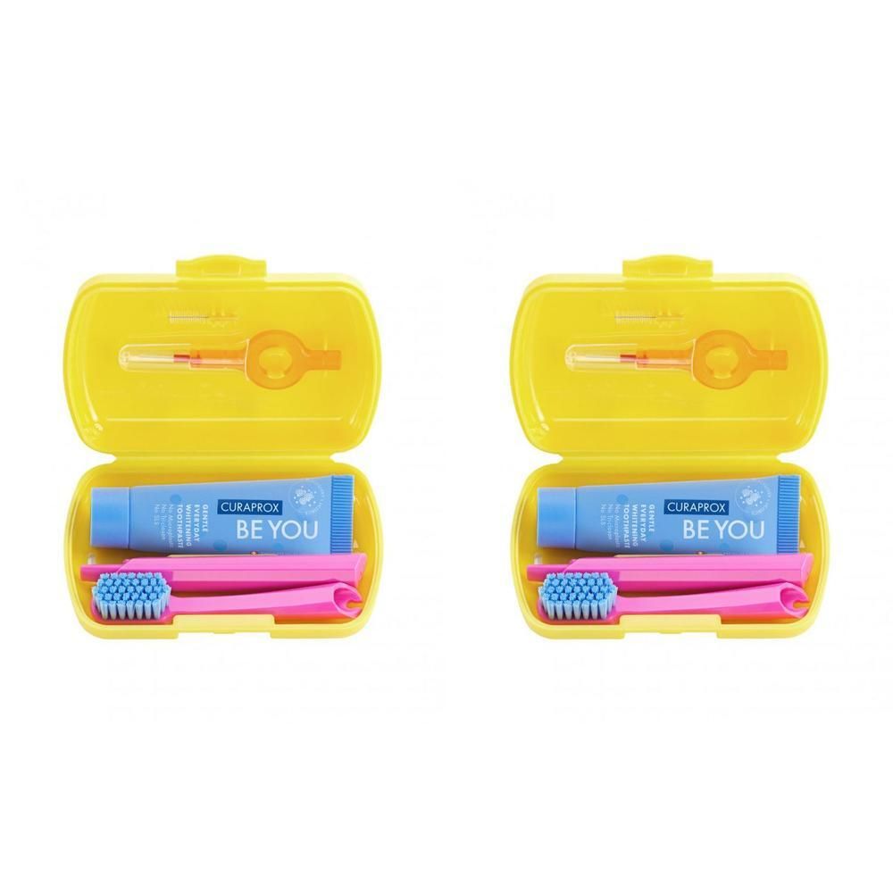 Zwei gelbe Reise-Sets. Jedes Set enthält eine Zahnbürste, Zahnpasta und eine Zahnzwischenraumbürste. Auf der Zahnpasta steht "BE YOU".