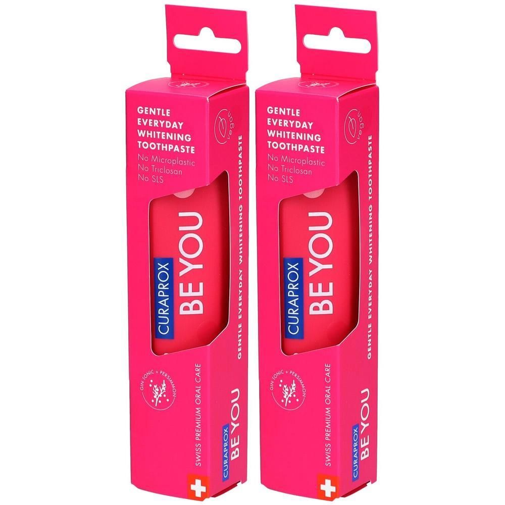Zwei rosa Verpackungen mit Zahnpasta. Aufschrift: CURAPROX BE YOU, Gentle Everyday Whitening Toothpaste. Swiss Premium Oral Care.