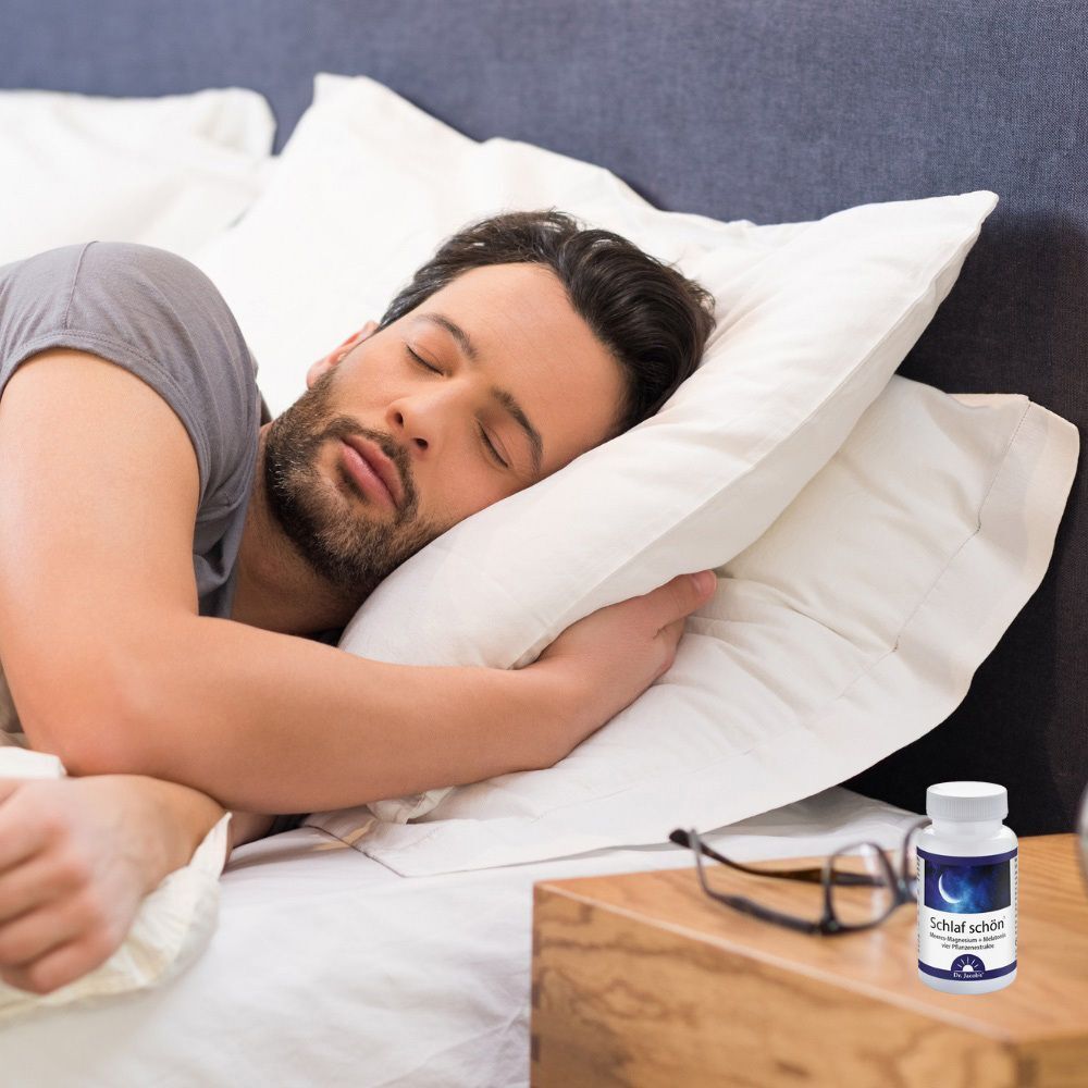 Mann schläft im Bett, Nachttisch mit Flasche SCHLAF SCHÖN Dr. Jacob's Tabletten. Brille liegt.