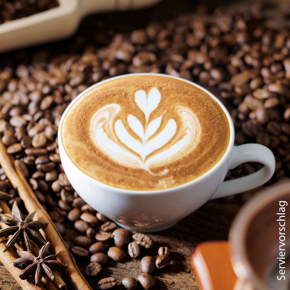 Kaffee mit Latte Art. Auf Holzuntergrund, umgeben von Kaffeebohnen und Gewürzen.