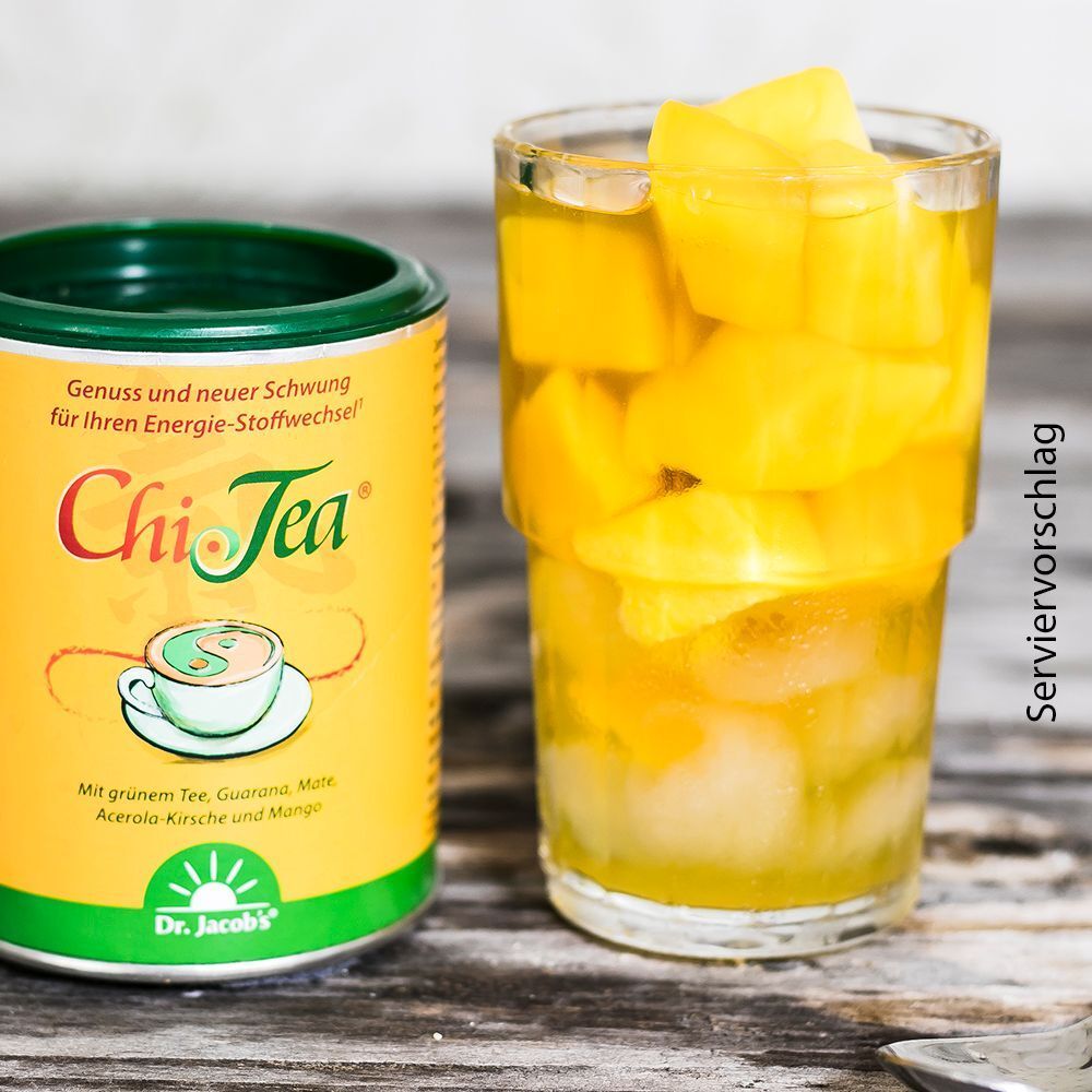 Glas mit Mango-Stücken und Chi-Tea-Getränk. Dose Chi-Tea daneben. Aufschrift: Chi-Tea, Dr. Jacob's.