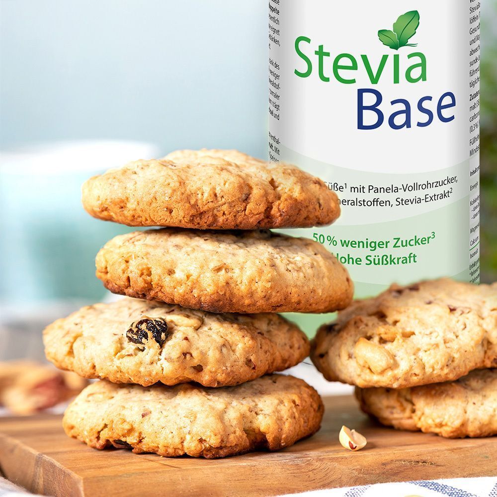 Fünf Kekse auf Holzbrett. Daneben Dose STEVIABASE. Aufschrift: Stevia Base, 50% weniger Zucker, Dr. Jacob's.