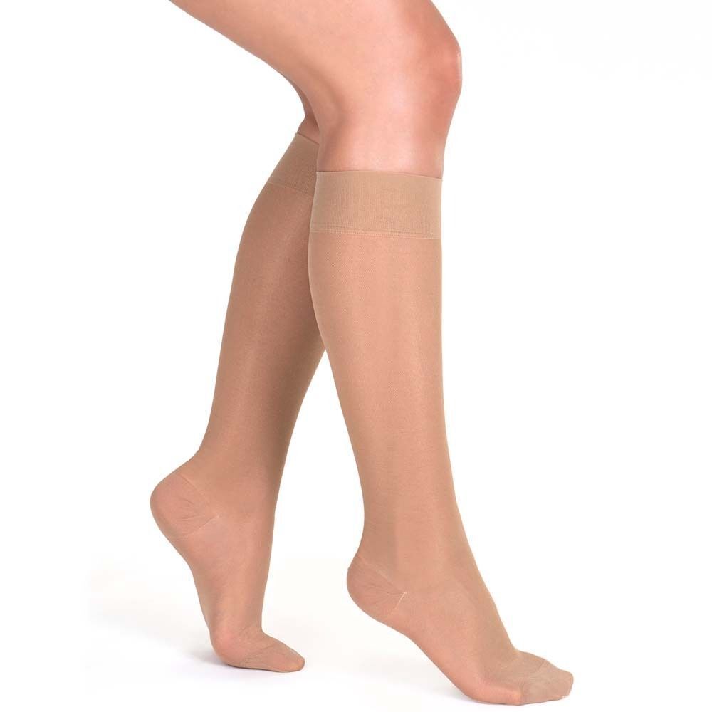 Beine mit Strümpfen. Strümpfe in Hautfarbe, bis zum Knie. Transparenter Stoff. Offener Fußbereich.