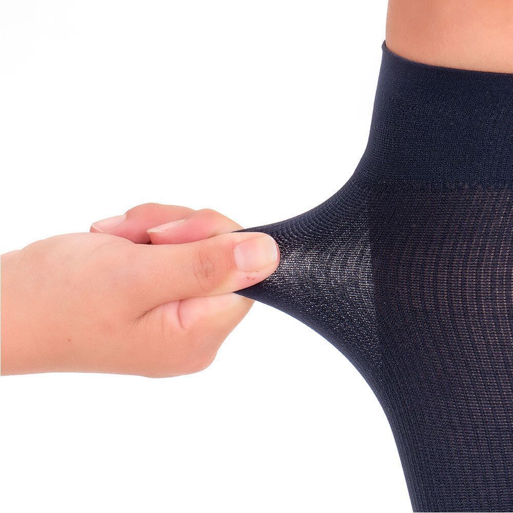 Nahaufnahme des blauen Strumpfmaterials. Eine Hand zieht das Material auseinander, um die Dehnbarkeit zu zeigen.