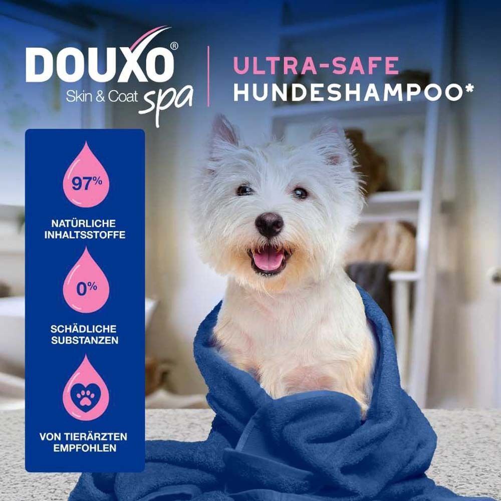 Ein weißer Hund in einem blauen Handtuch. Text: DOUXO® SPA Ultra-safe Hundeshampoo. 97% natürliche Inhaltsstoffe, 0% schädliche Substanzen.
