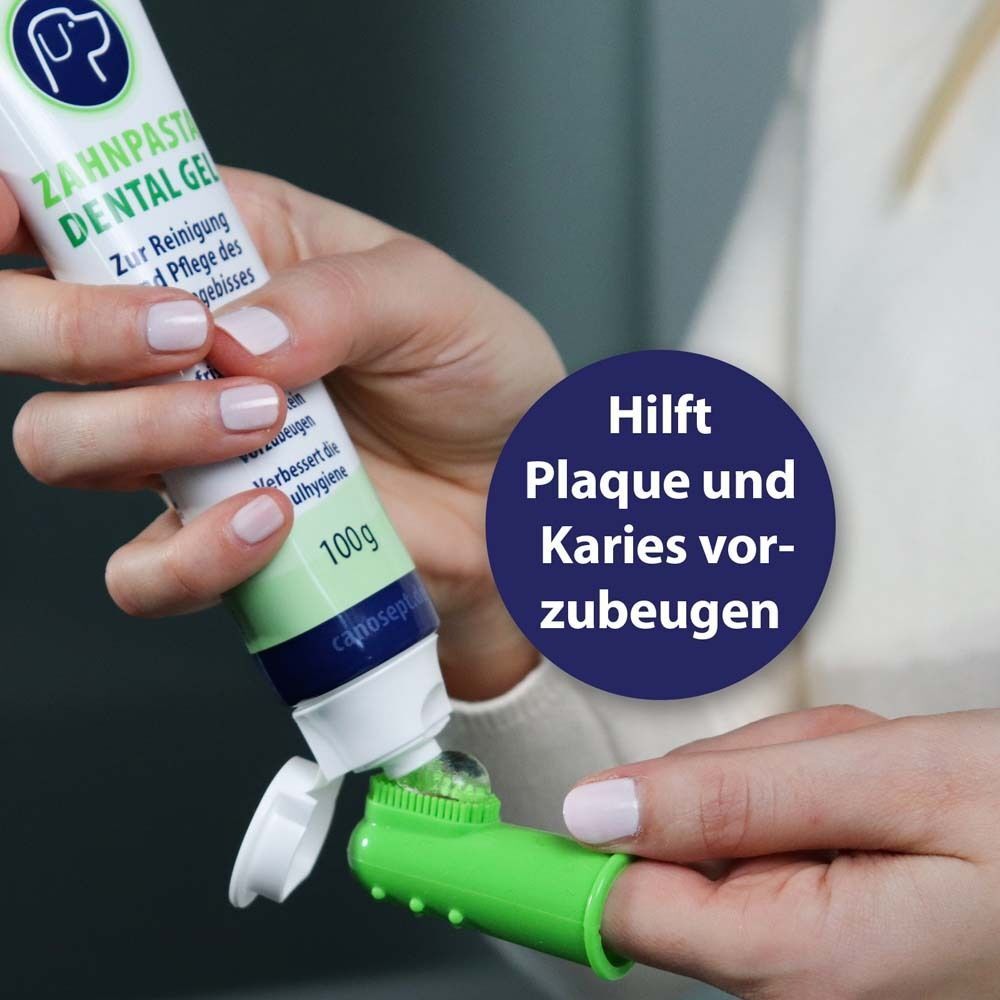 Zahnpasta auf Finger-Zahnbürste. Text: Hilft Plaque und Karies vorzubeugen.