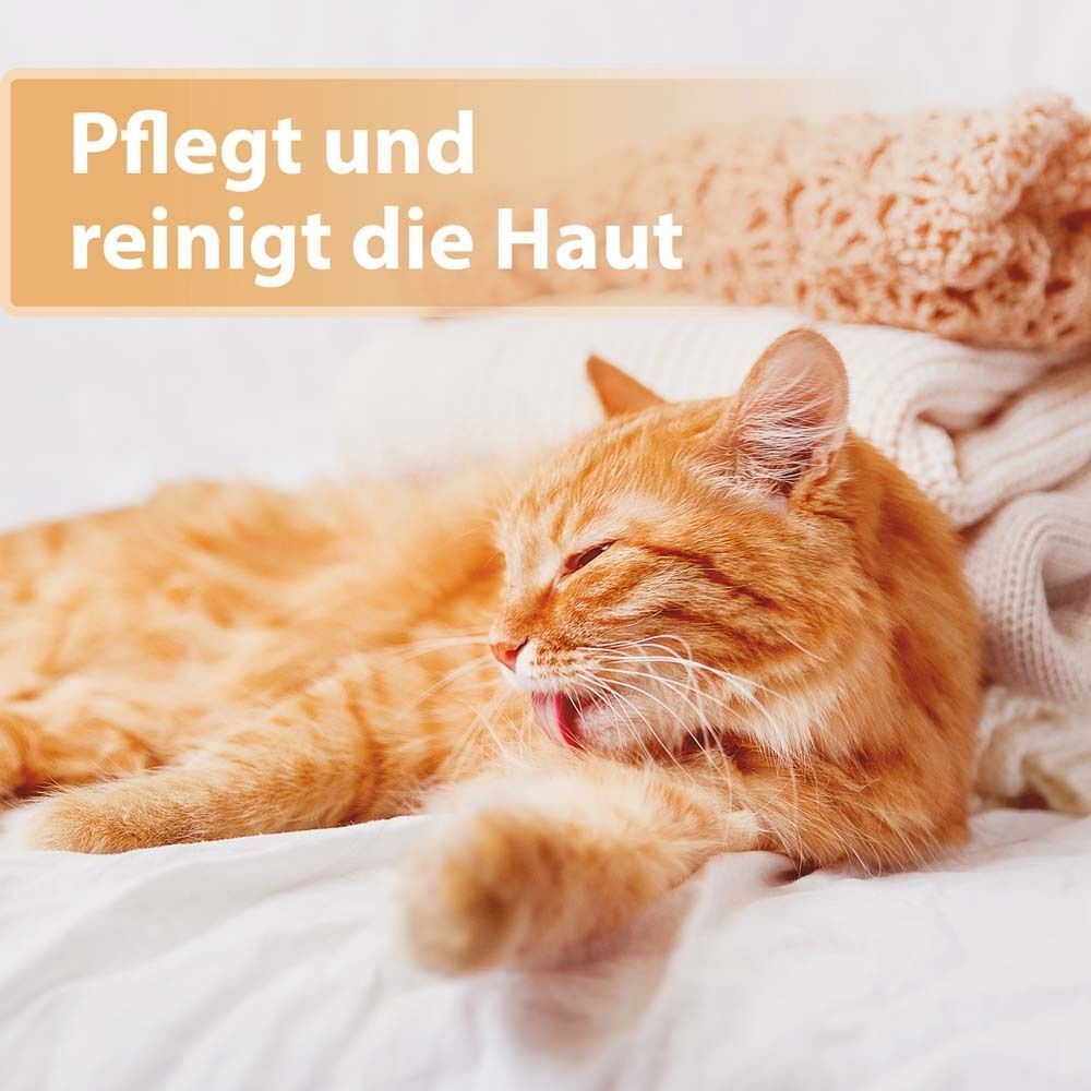 Katze auf weißer Decke. Text: Pflegt und reinigt die Haut.