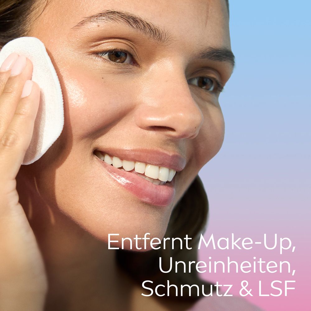 Frau reinigt ihr Gesicht mit einem Wattepad. Text: Entfernt Make-Up, Unreinheiten, Schmutz & LSF.