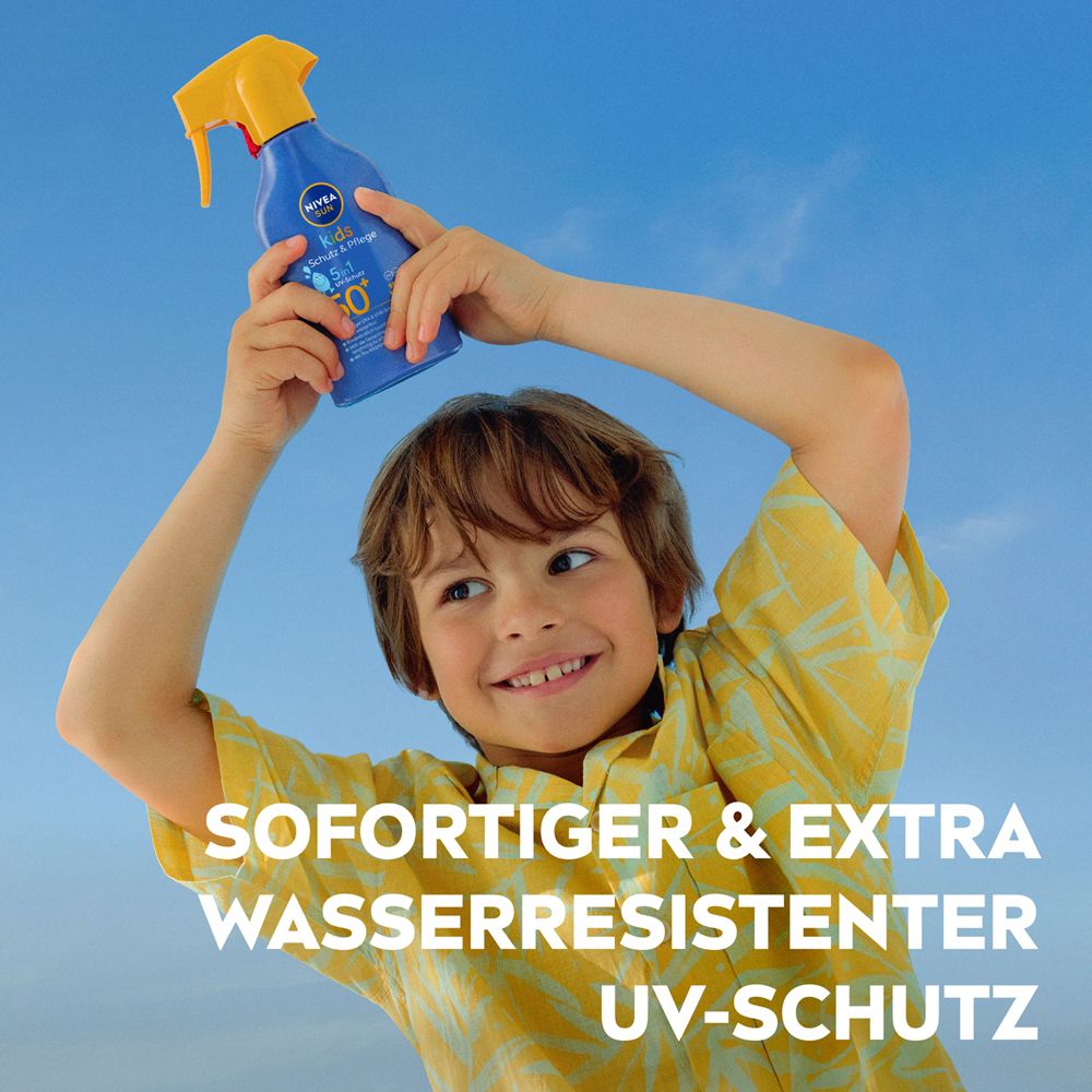 Kind hält NIVEA Sun Kids Sonnenspray LSF 50+ über dem Kopf, blauer Himmel im Hintergrund.