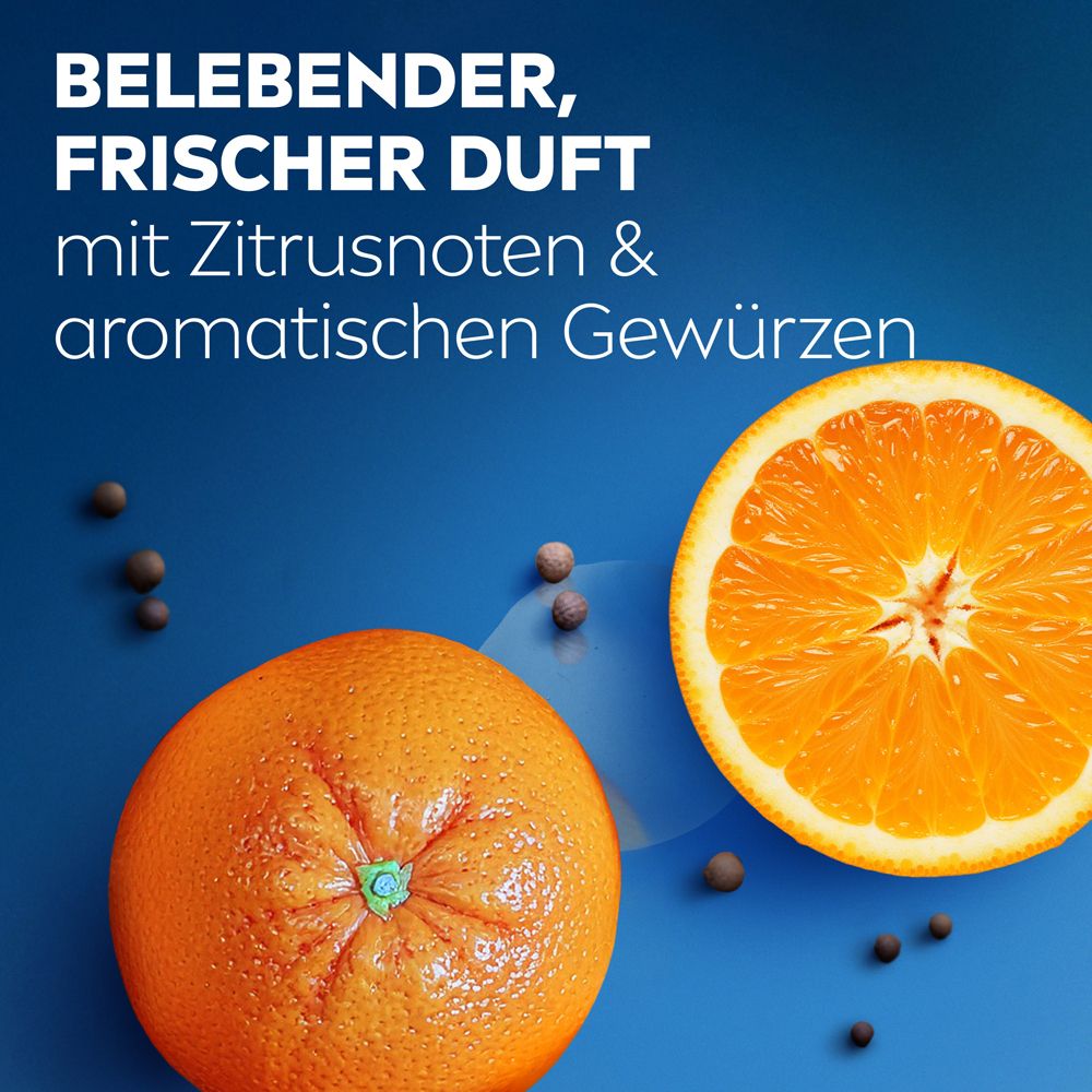 Eine ganze Orange und eine halbierte Orange mit Pfefferkörnern auf blauem Hintergrund.